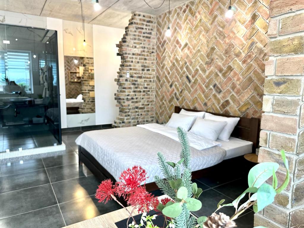 a bedroom with a bed and a brick wall at Comfortable apartments in the city center, near the theater and Zlata Plaza in Rivne