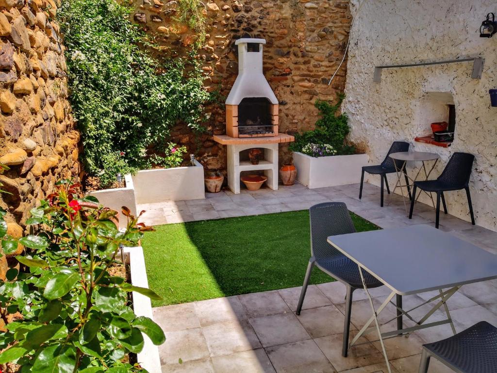 un patio con mesa, sillas y chimenea en Casa rural "Cuenta la Leyenda..." en Bulbuente