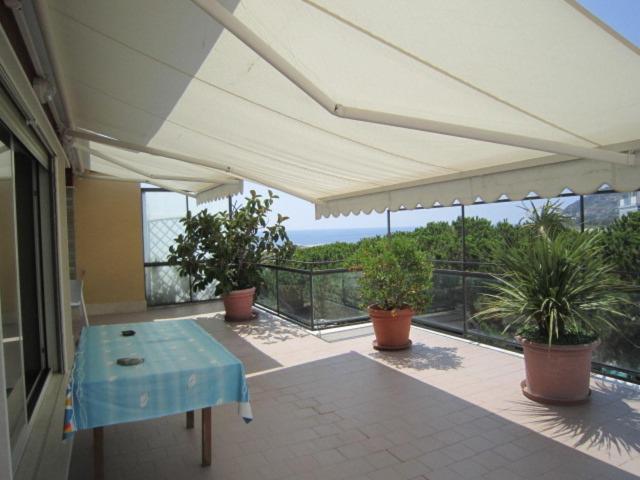 a patio with a blue table and potted plants at Attico Grace Sanremo near the sea in Sanremo