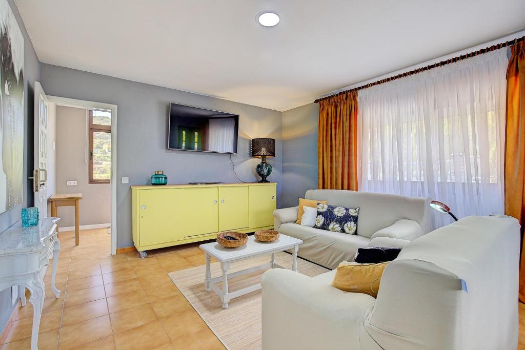 uma sala de estar com um sofá branco e uma mesa em Lightbooking La Carajita Villa de Mazo em Mazo