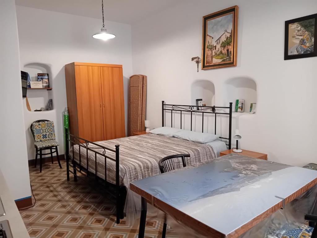 a bedroom with two beds and a table in it at "la casa dell'architetto" con terrazza panoramica in centro storico e a due passi dal porto in Lipari