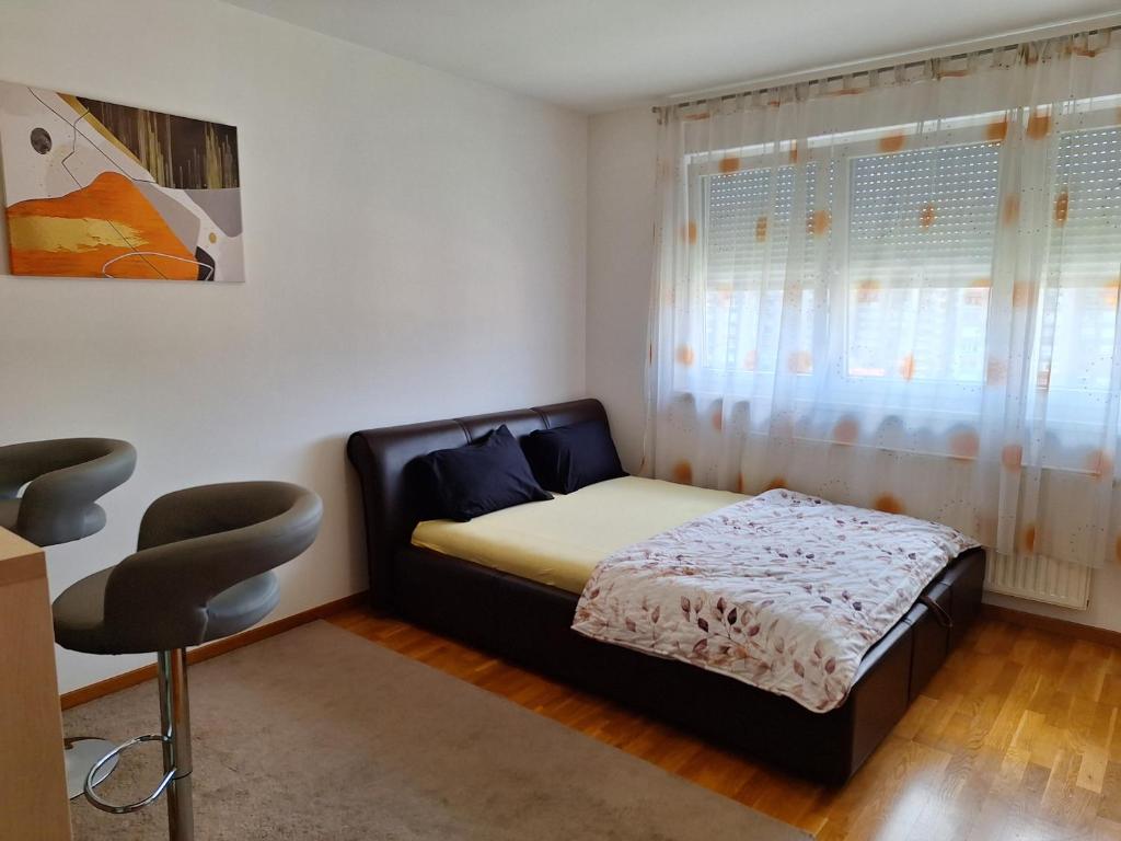 a small bedroom with a bed and a window at Apartman Sarah - Autobuska Stanica in Tuzla