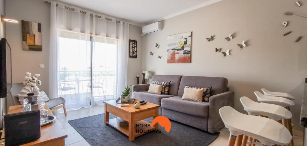 a living room with a couch and a table and chairs at #093 Vista das Ondas by Home Holidays in Olhos de Água