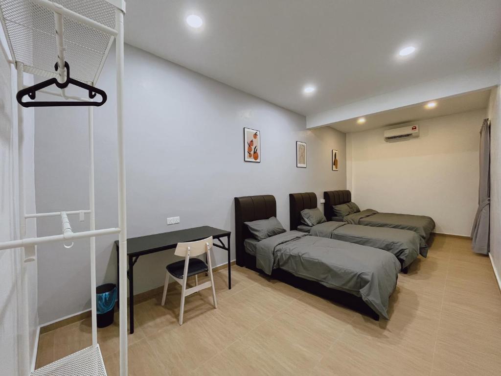 een slaapkamer met 2 bedden en een bureau. bij Elonna Homestay in Jerantut