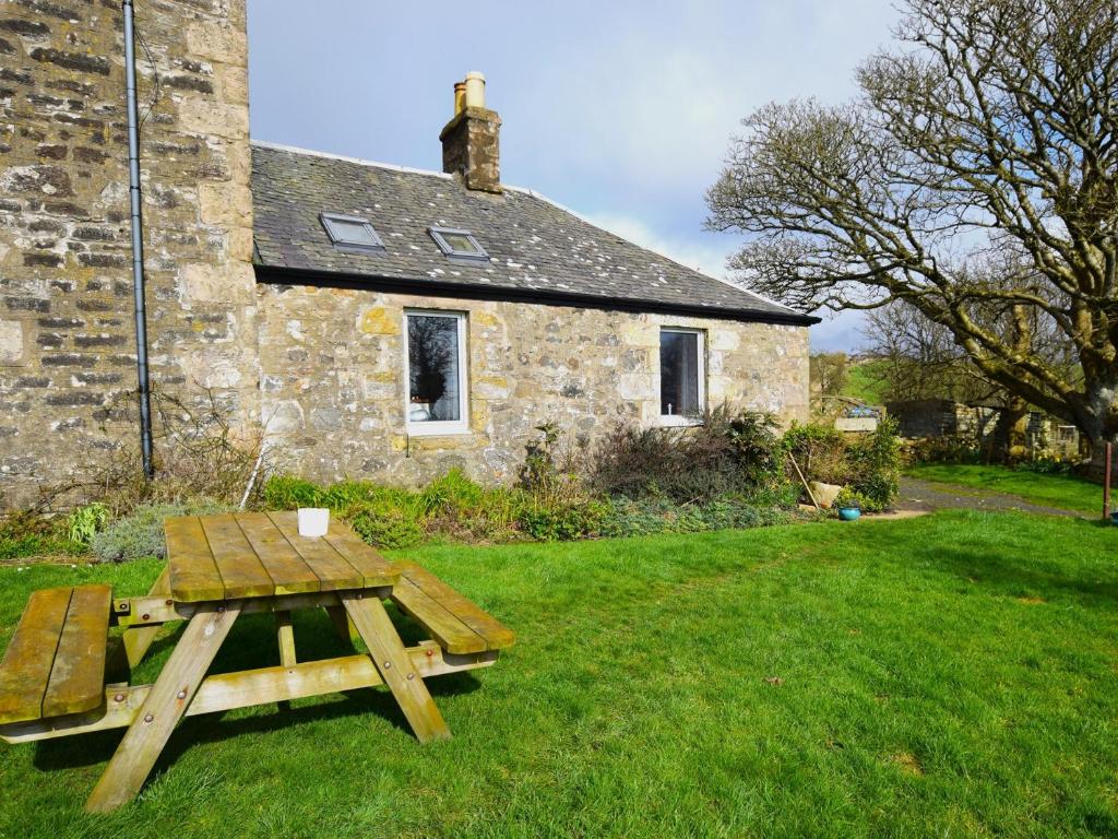 a picnic table in front of a stone house at 1 bed in Kilmory CA344 in Kilmory