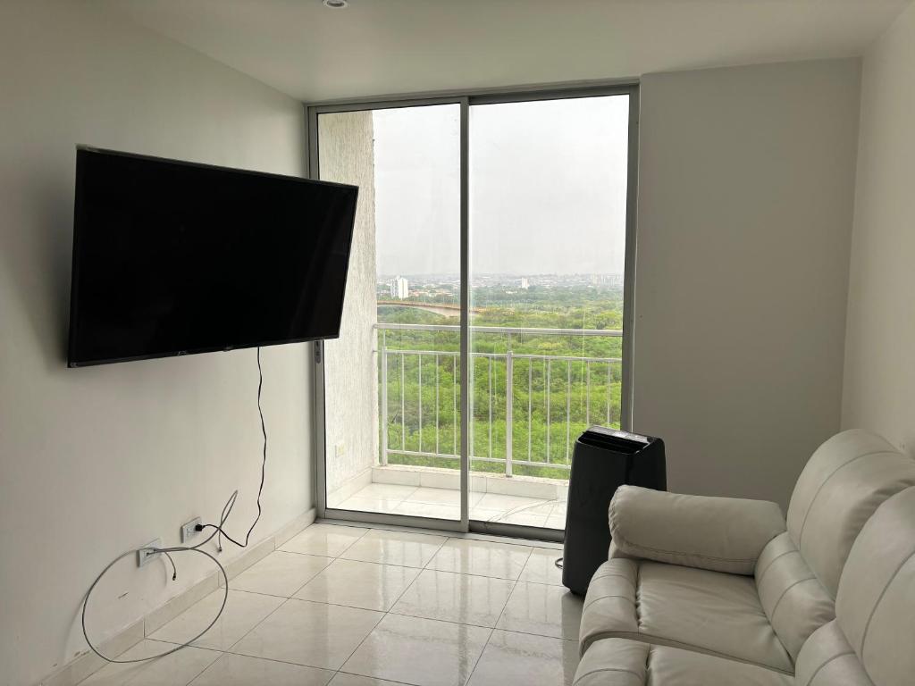 uma sala de estar com um sofá e uma grande janela em Apartamento con excelentes comodidades em Cúcuta