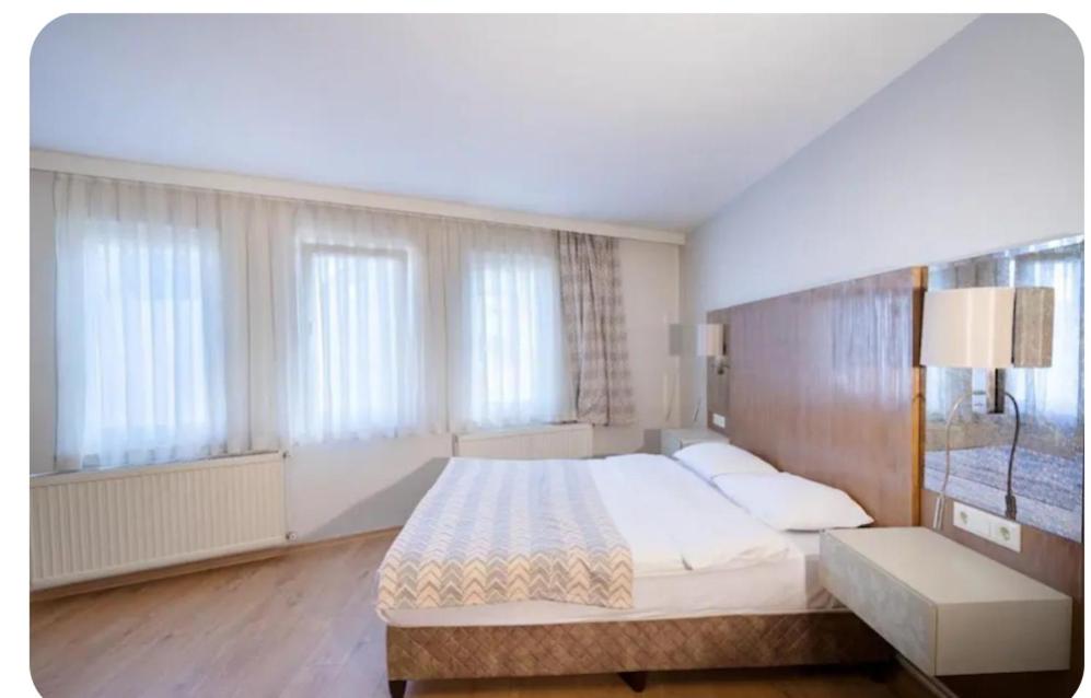 a bedroom with a large bed and some windows at Telmessos in Gebze