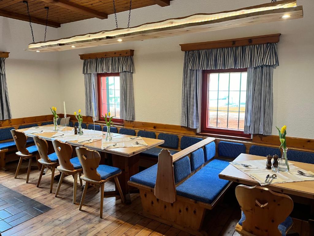 a dining room with wooden tables and blue chairs at Landgasthof Marhube in Baldramsdorf