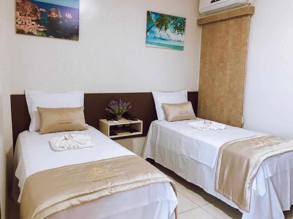 HOTEL VIANA في Barra do Corda: سريرين في غرفة ذات أغطية بيضاء