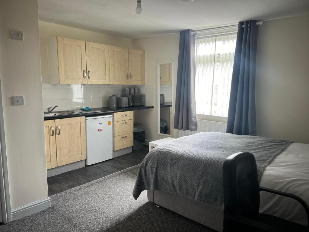 a small bedroom with a bed and a kitchen at Studio Flat 7 With Private Shower & WC in Nottingham