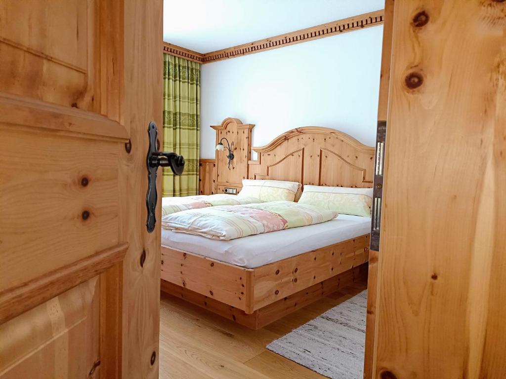 a bedroom with a bed with a wooden headboard at Ferienhaus Innerzarge in Tux