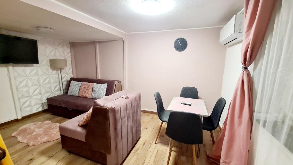 sala de estar con sofá, mesa y sillas en Big Base Apartment en Budapest