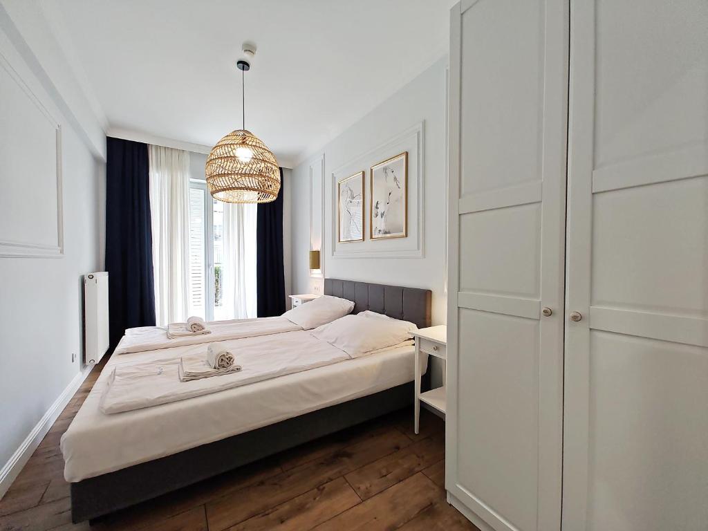 sypialnia z łóżkiem i żyrandolem w obiekcie Casa Marina Spa by Baltic Home w Świnoujściu