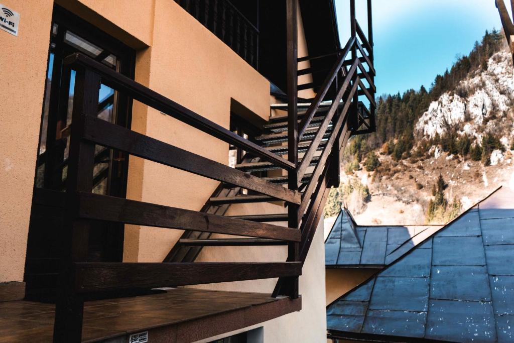 a wooden staircase on the side of a building at Pensiunea Casa Soarelui in Podu Dîmboviţei