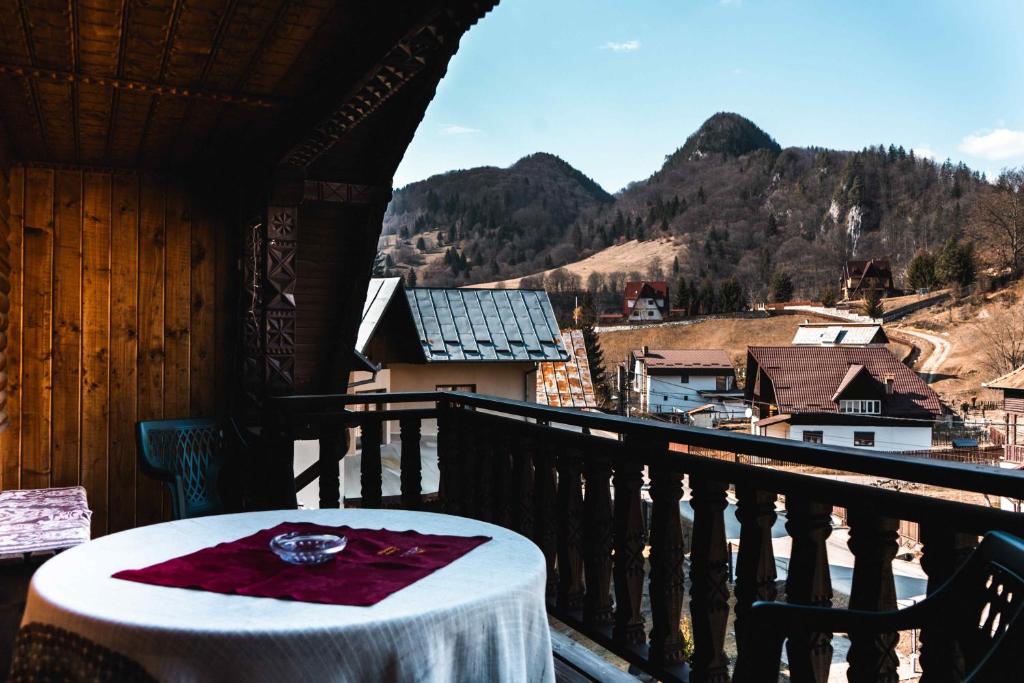 a table on a balcony with a view of the mountains at Pensiunea Casa Soarelui in Podu Dîmboviţei