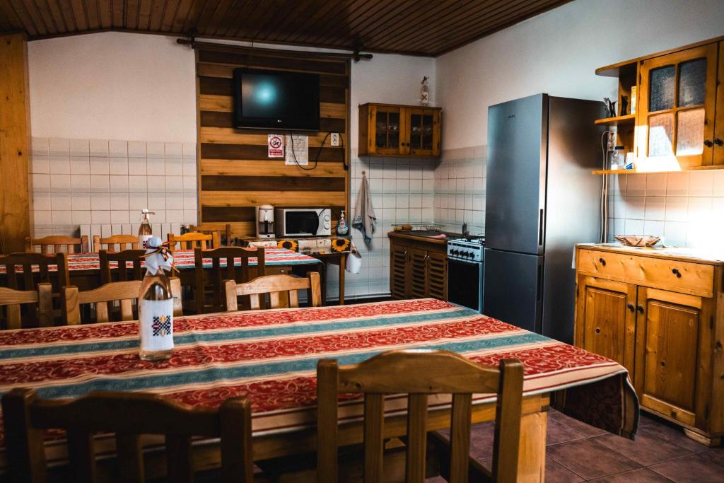 a kitchen with a table and a refrigerator at Pensiunea Casa Soarelui in Podu Dîmboviţei