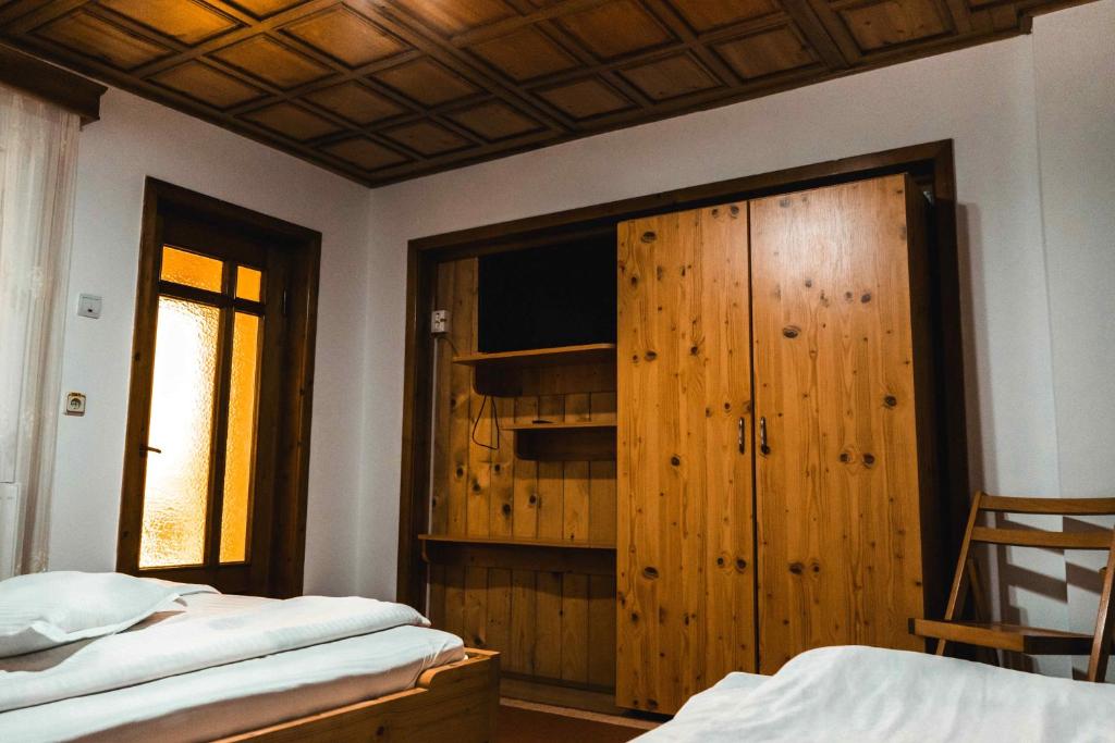 a bedroom with a bed and a wooden closet at Pensiunea Casa Soarelui in Podu Dîmboviţei