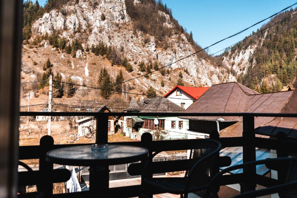 a table on a balcony with a view of a mountain at Pensiunea Casa Soarelui in Podu Dîmboviţei