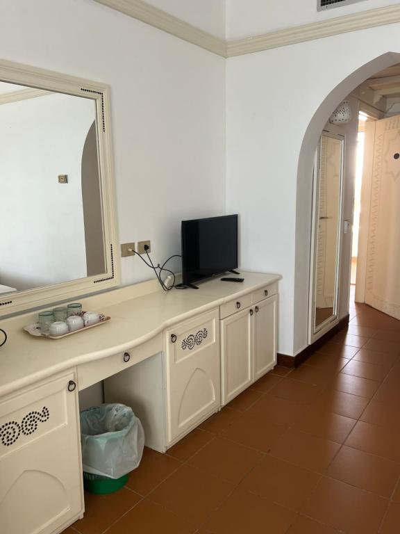 a bathroom with a vanity with a mirror and a television at Domina coral bay resort direct beach and lake 1 in Sharm El Sheikh