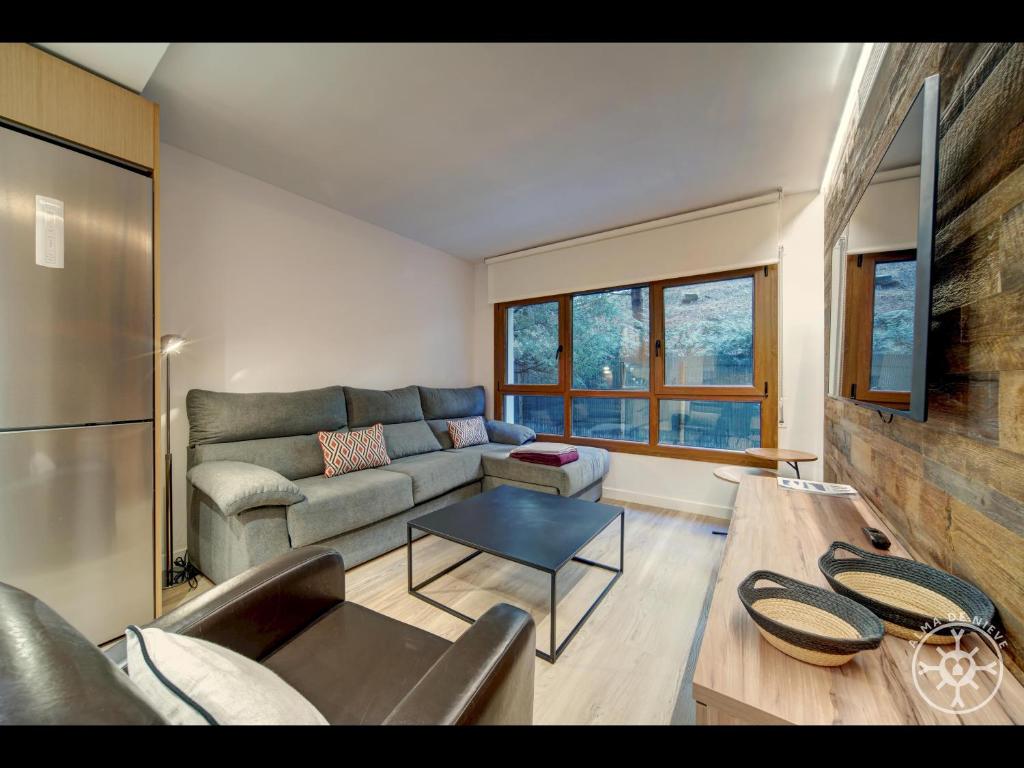 sala de estar con sofá y mesa en MANAUD de Alma de Nieve, en Baqueira Beret