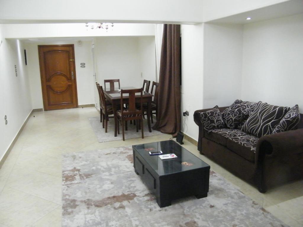 uma sala de estar com um sofá e uma mesa em Mohandeseen apartment المهندسين عائلات em Cairo