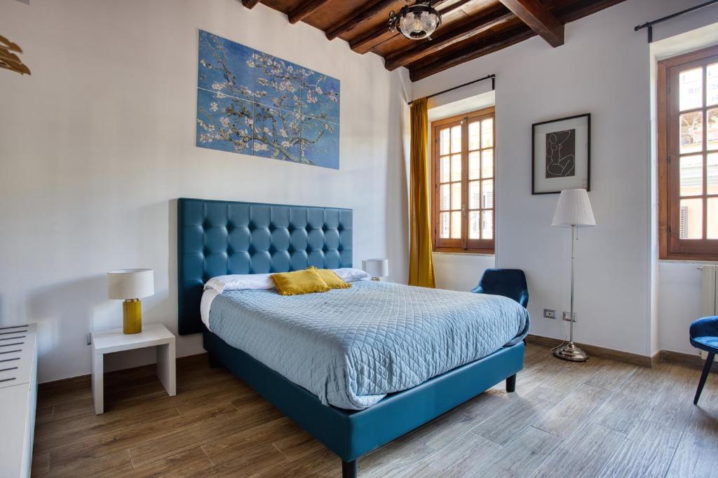1 cama azul en un dormitorio con paredes blancas y suelo de madera. en URBANA 37 Maison, en Roma
