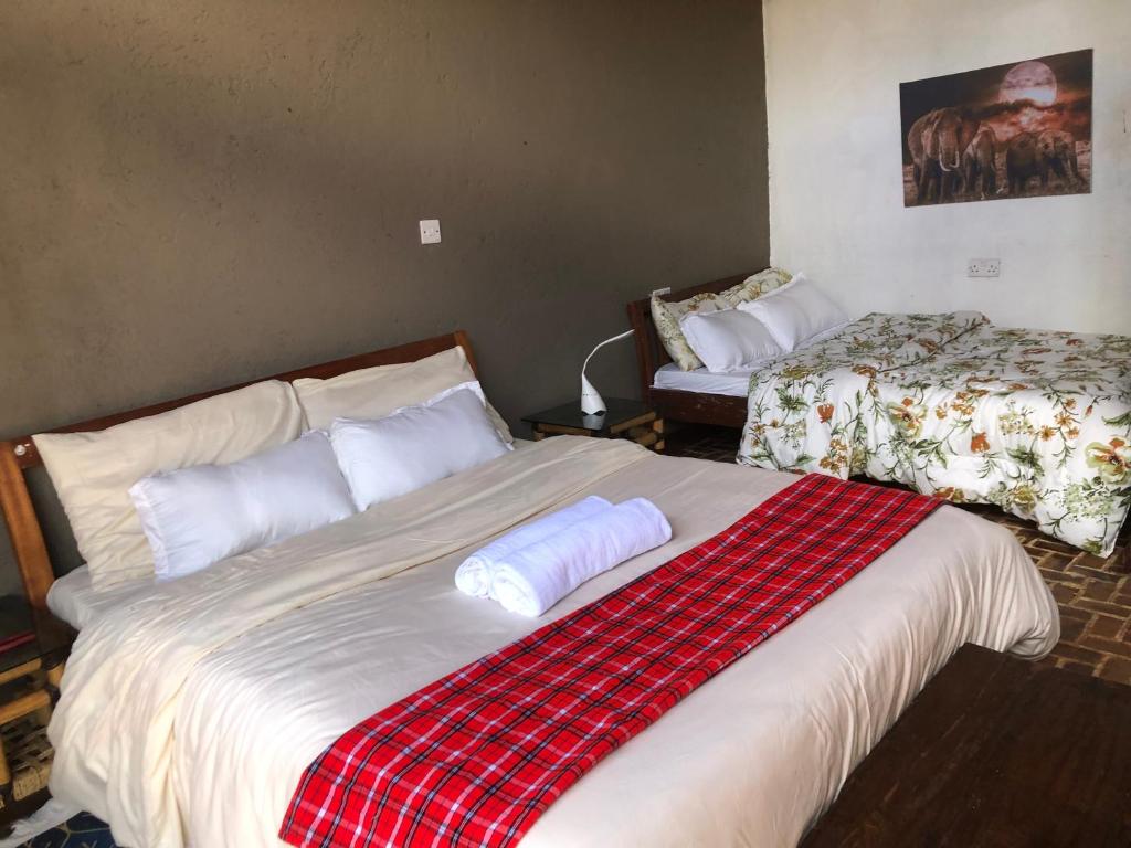a bedroom with a large bed with a plaid blanket at Mashambani Cottages in Nyahururu