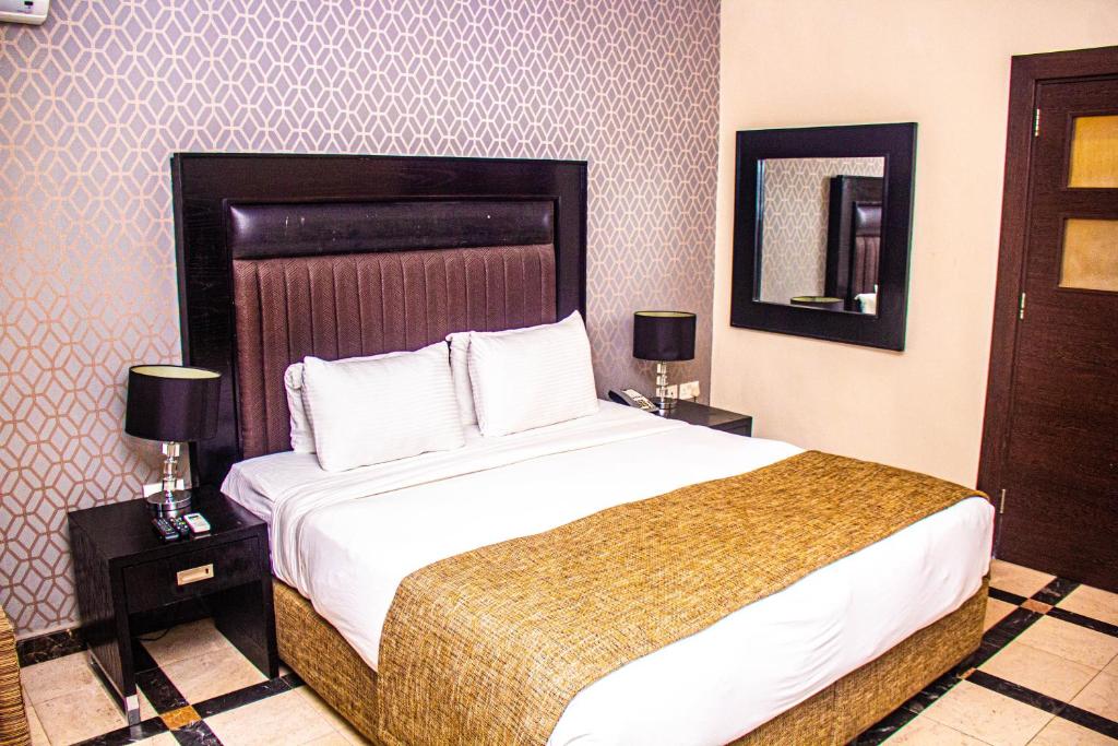 Gwarinpaにある2bedroom Masters Apartmentのベッドルーム1室(大型ベッド1台、ランプ付きのナイトスタンド付)