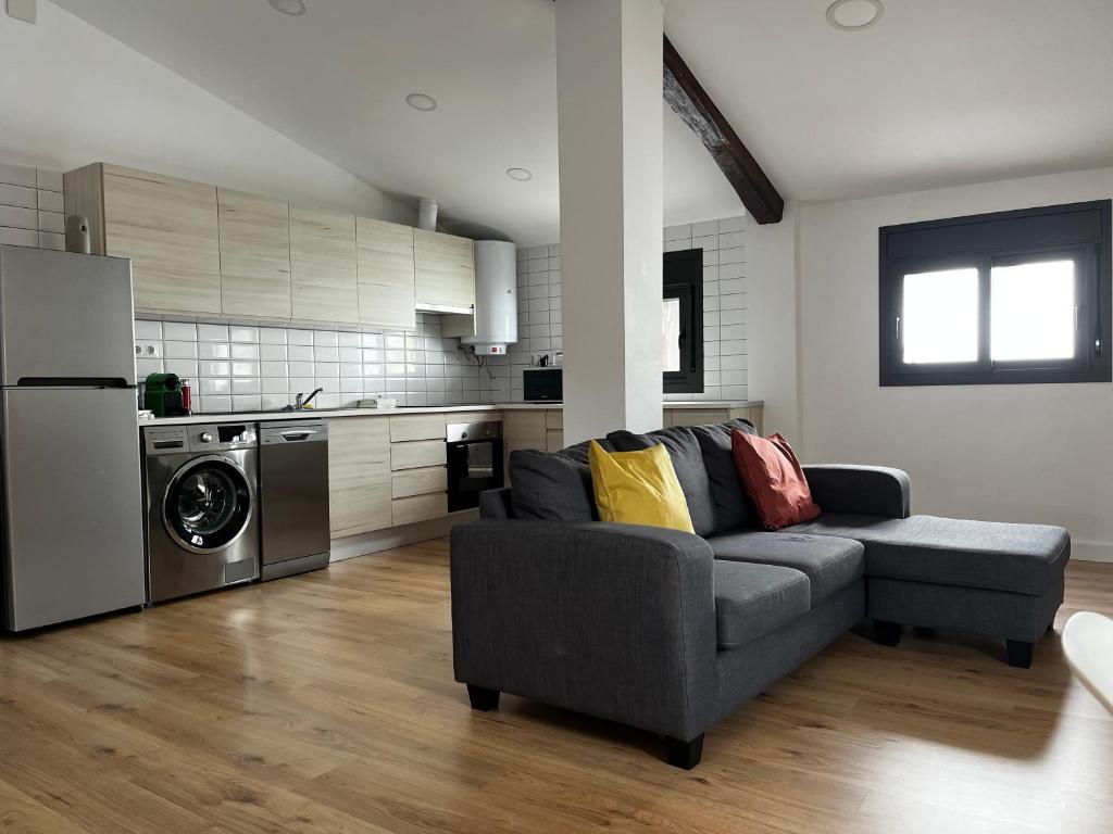 a living room with a couch and a kitchen at Mon Residence Sant Jeroni in Manresa