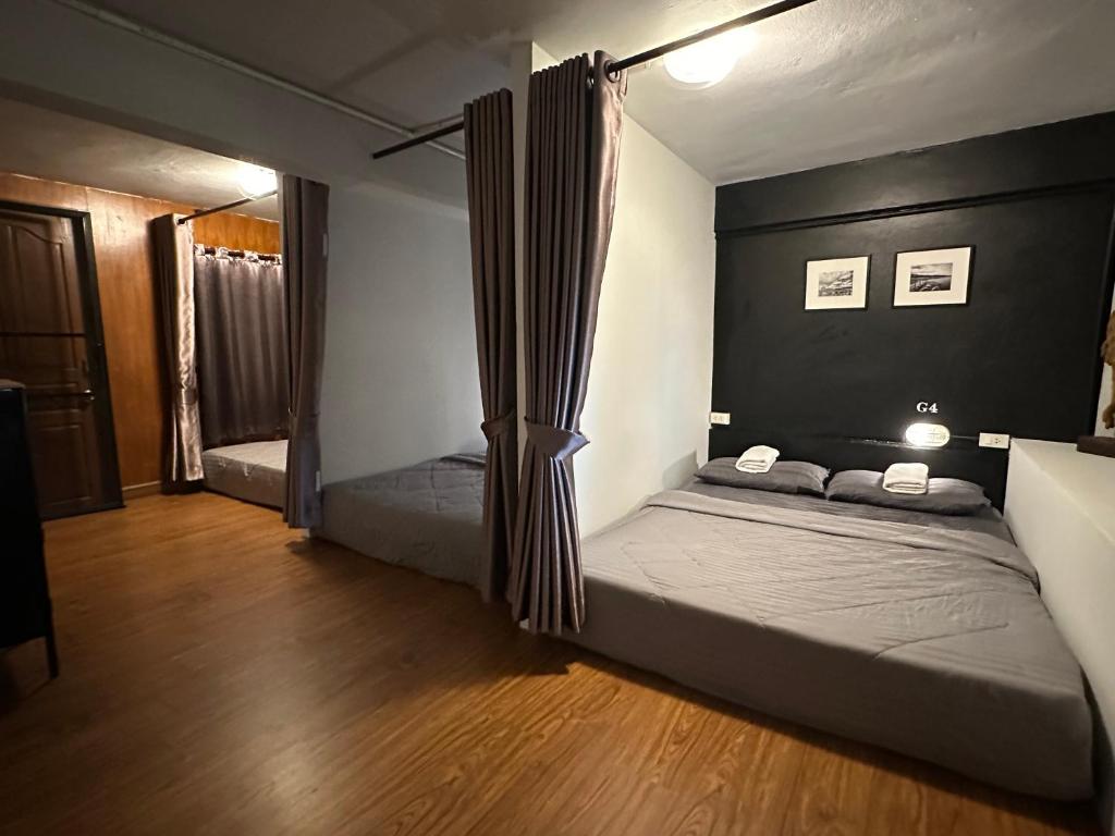 a bedroom with two beds and a black wall at 84 Gallery in Chiang Mai