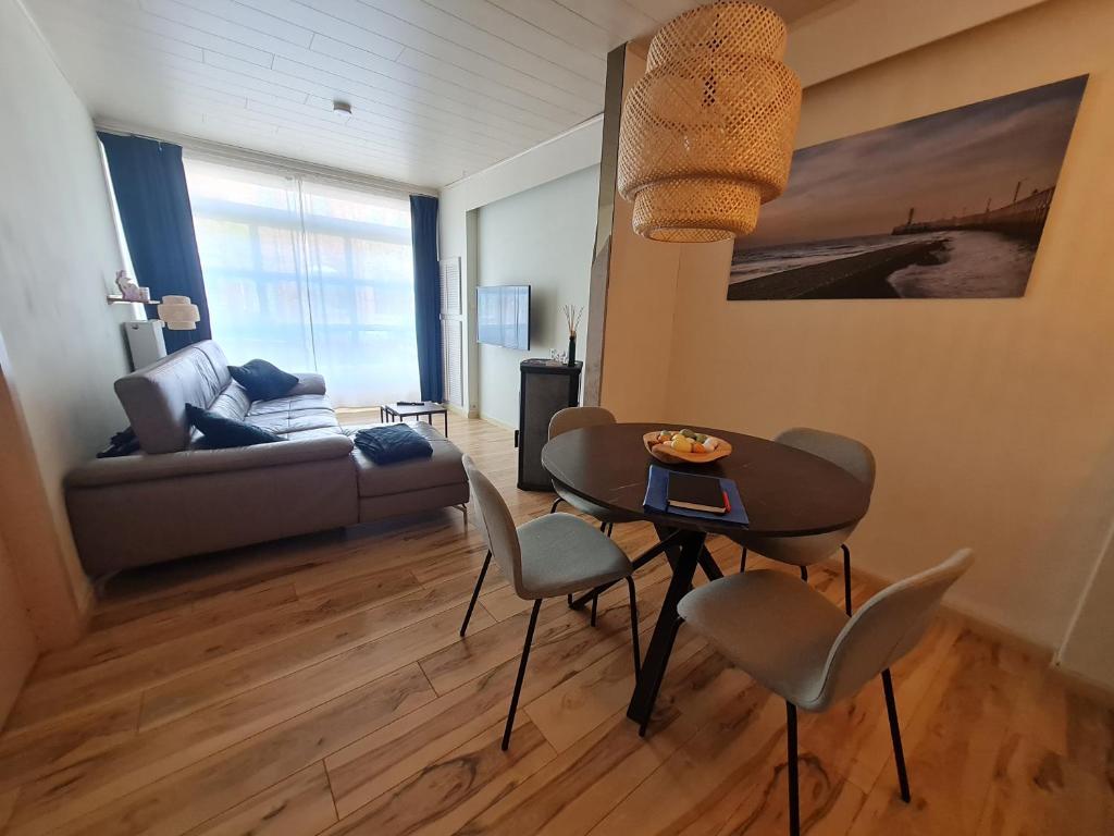 ein Wohnzimmer mit einem Tisch, Stühlen und einem Sofa in der Unterkunft Gasthuis In't Stad in Nieuwpoort