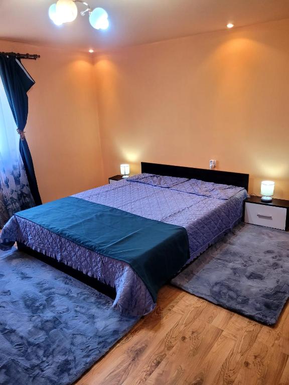 a bedroom with a bed with a blue comforter at Casa OPRIȚA in Hobiţa Grădişte