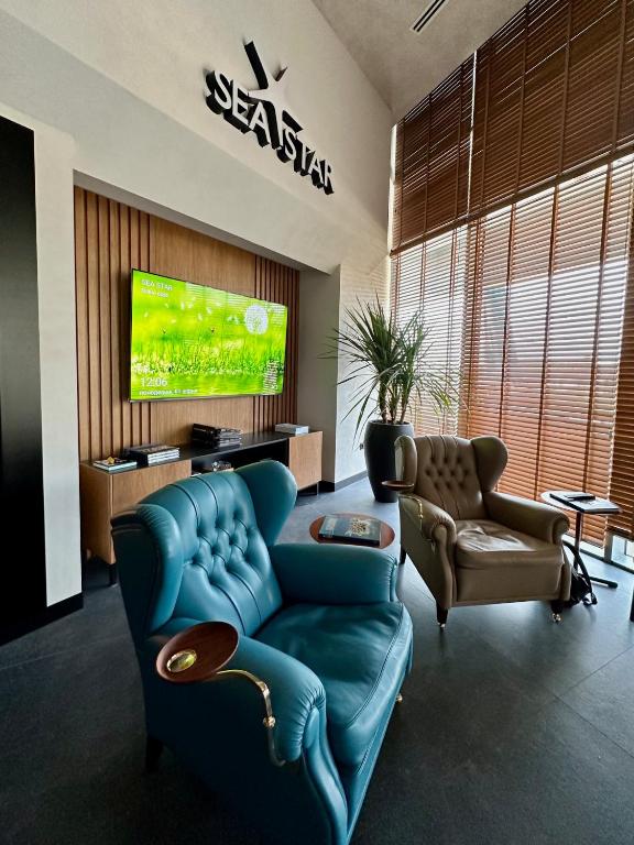 a living room with a blue couch and a tv at Sea Star Budva in Budva