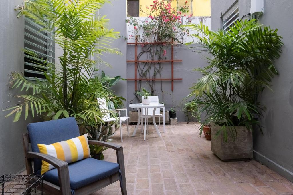 a patio with plants and a chair and a table at Seaside Caribbean Comfort - Between Beach and City in San Juan