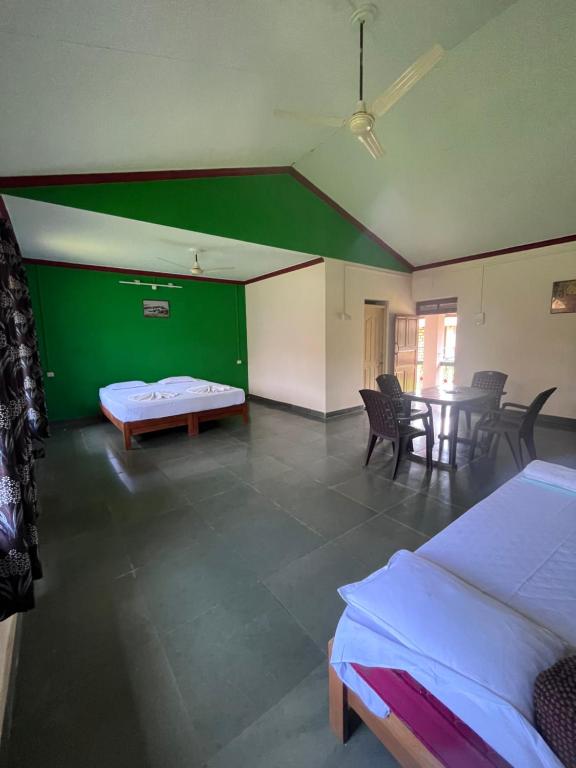 a room with two beds and a table and chairs at Green valley jungle resort in Pernem
