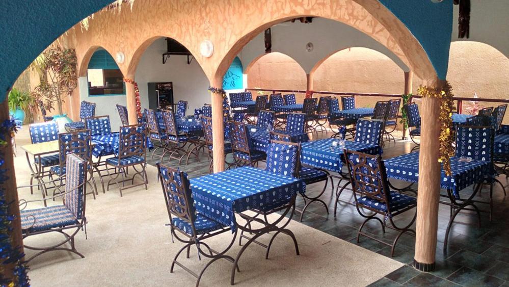 un grupo de mesas y sillas azules en una habitación en Sulcata Lodge en Ouoran