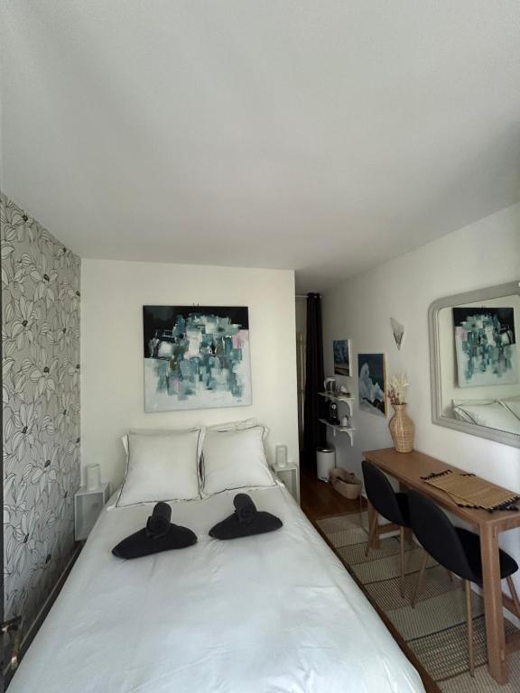 Un dormitorio con una cama con dos sombreros. en Chambre d hôte - Bambou, en Saint-Maur-des-Fossés