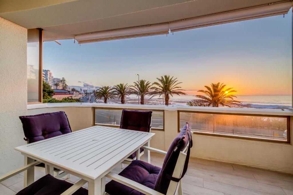 un tavolo e sedie su un balcone con vista sull'oceano di Sundowner Views a Città del Capo