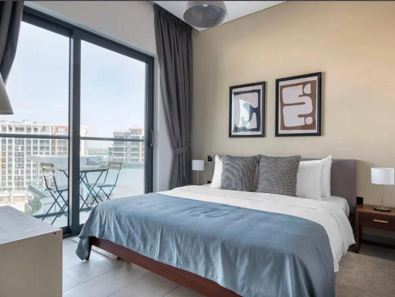 1 dormitorio con 1 cama grande y balcón en Budget Staying - Comfortably and Luxuriously in Dubai, en Dubái