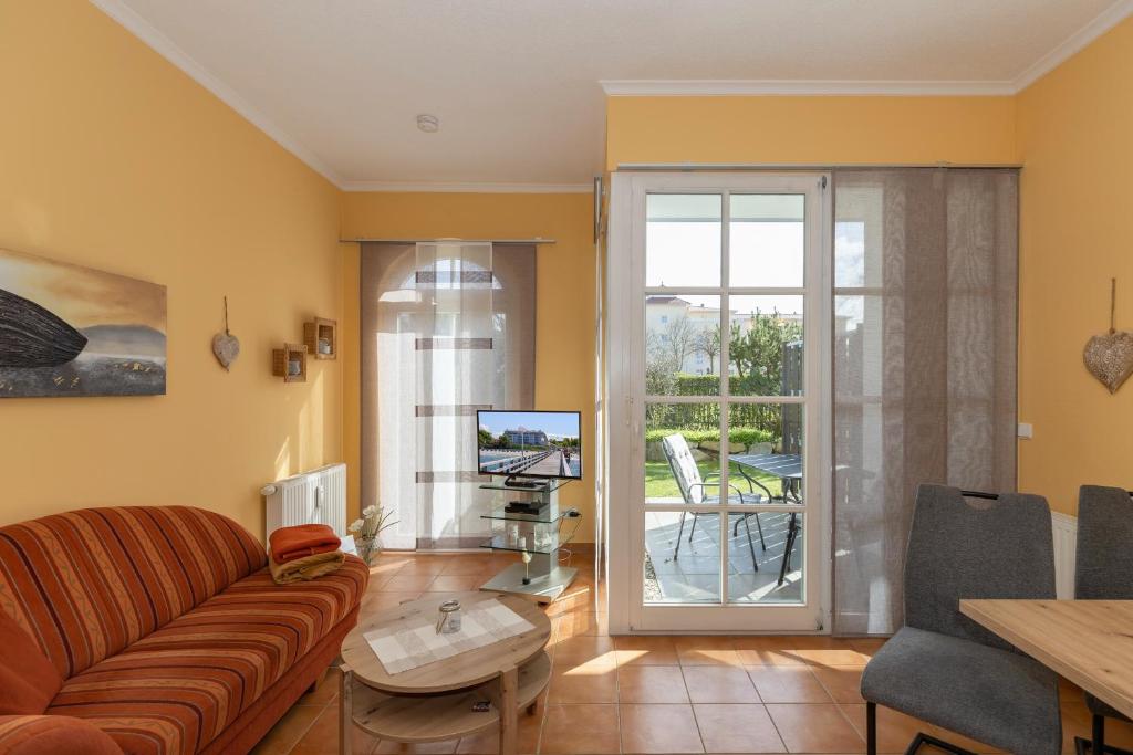 - un salon avec un canapé, une télévision et une table dans l'établissement Apartmenthaus Atlantik Apartmenthaus Atlantik 007, à Kühlungsborn