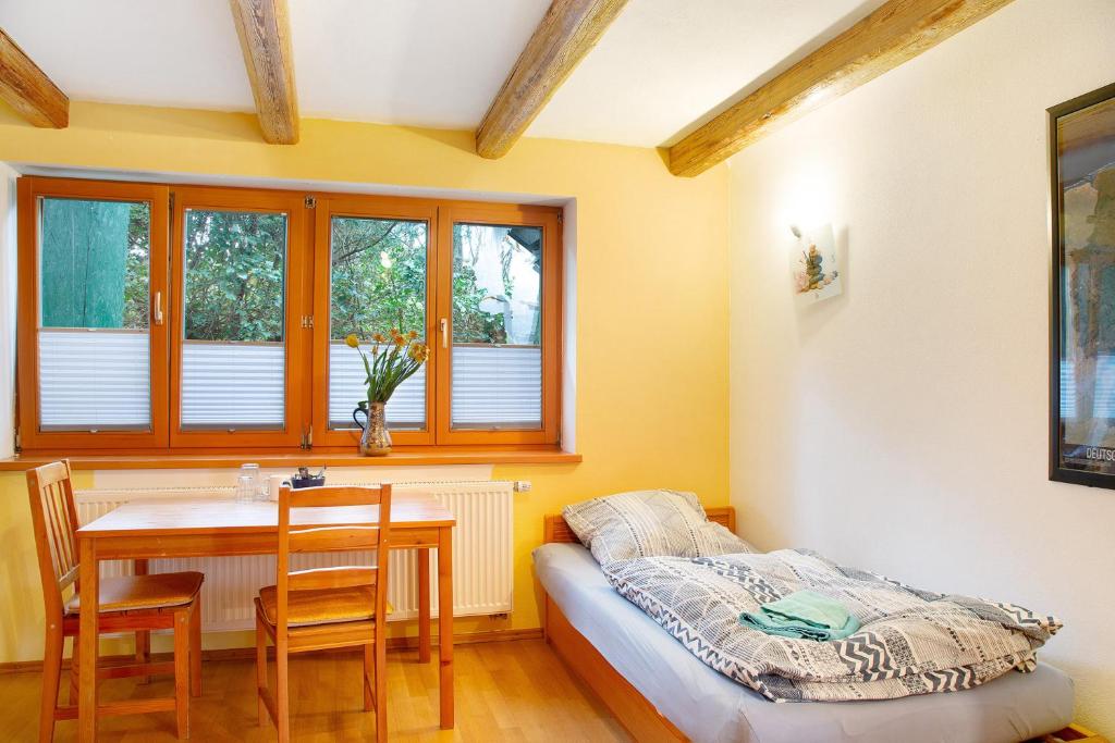 Habitación con cama, mesa y sillas. en Time to relax and enjoy nature, en Grünwald