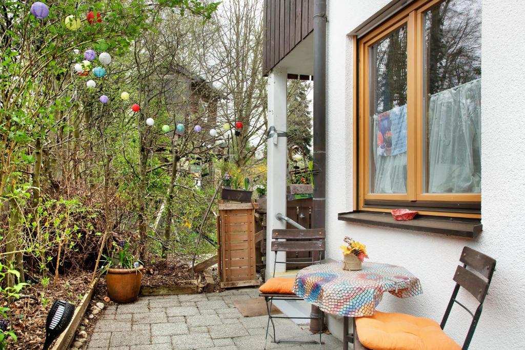 格倫沃德的住宿－Milchtütenzimmer - Upcycling，一个带桌椅的庭院和一个窗户。