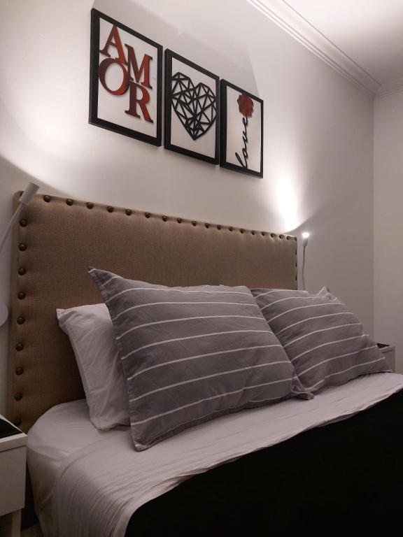 1 dormitorio con 1 cama con 4 cuadros en la pared en Lo que buscabas en Nueva Cordoba en Córdoba