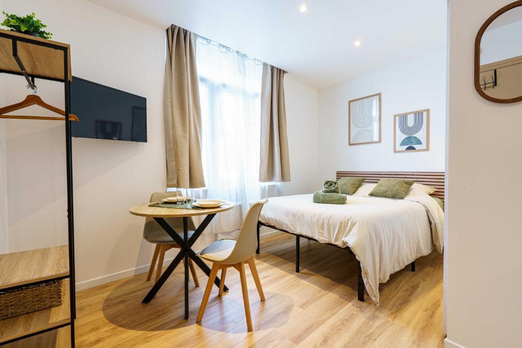 une chambre avec un lit, une table et une fenêtre dans l'établissement Studio Ensoleillé 2pers wifi, à Saint-Quentin