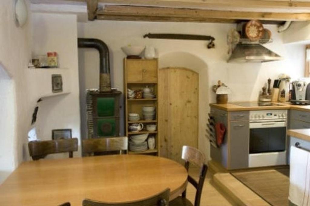 een keuken met een houten tafel en een fornuis bij Das spezielle Ferienhaus Heidi - b48536 in Maienfeld