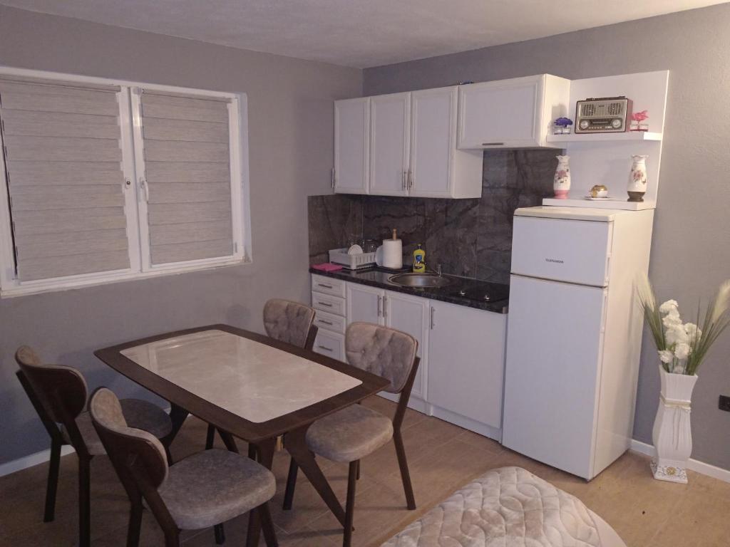 uma pequena cozinha com uma mesa e uma mesa e cadeiras em Apartments Calimero em Mostar
