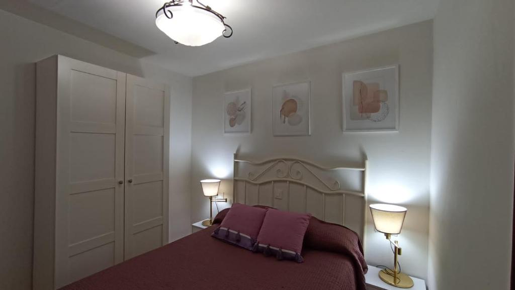 a bedroom with a large bed with two lamps at La Casina de MIRI in Tazones
