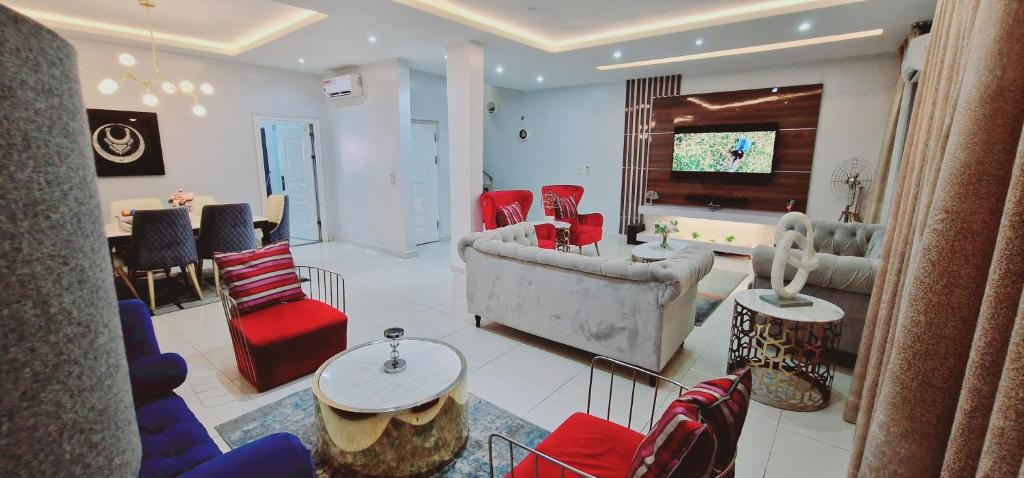 a living room with red and blue chairs and a television at Luxury 3-Bed house in gated estate with pool Lekki in Maiyegun