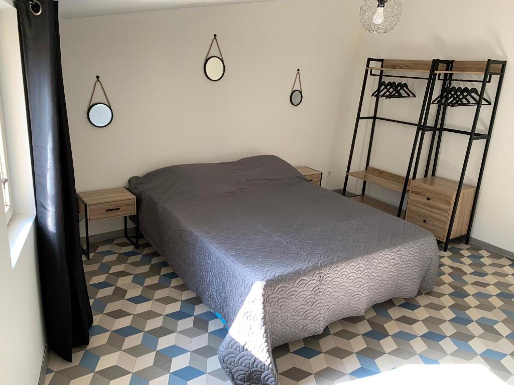 ein Schlafzimmer mit einem Bett in einem Zimmer mit einem karierten Boden in der Unterkunft Ma petite étoile sur les toits in Pézenas