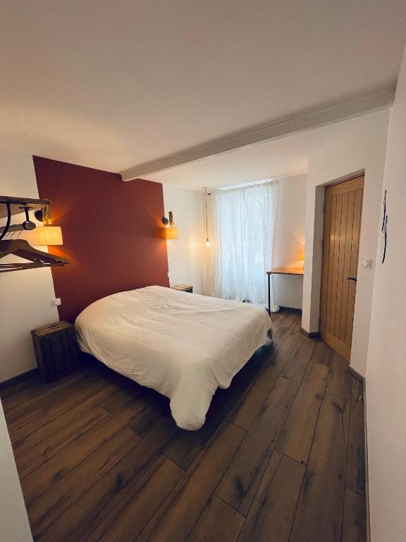 une chambre avec un lit blanc et un parquet dans l'établissement Maison de Felix, à Saint-Androny